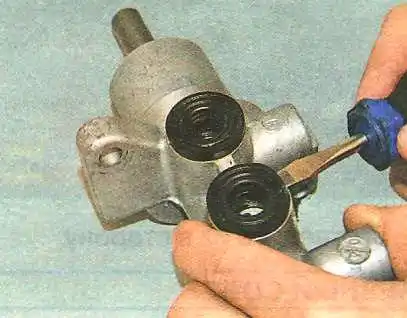 Замена главного тормозного цилиндра Авео Шевролет извлеките втулки из отверстий корпуса цилиндра.