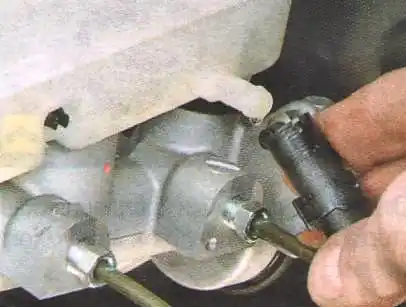 Замена главного тормозного цилиндра Авео Шевролет Отсоедините шланг от бачка главного тормозного цилиндра.
