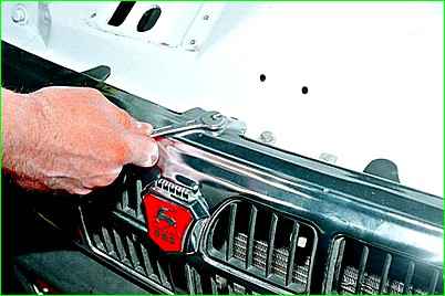 Extracción de la rejilla y el panel superior del embellecedor del radiador