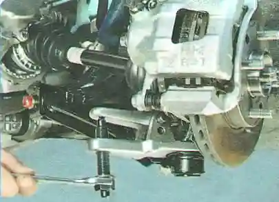 Установите съемник шаровых шарниров и выпрессуйте палец из кулака