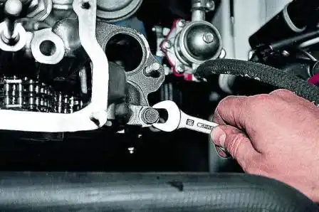 Замена прокладки головки блока цилиндров ВАЗ-2107 Ключом «на 13» отворачиваем болт крепления головки блока цилиндров около распределителя зажигания