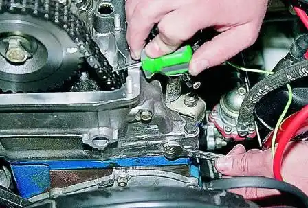 Замена успокоителя цепи привода распределительного вала ВАЗ-2107 Удерживая отверткой успокоитель цепи, ключом «на 10» отворачиваем два болта его крепления