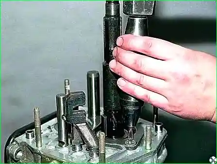 Ударной отверткой отворачиваем четыре винта крепления стопорной пластины подшипника