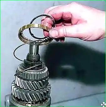 снимаем стопорное кольцо, а также блокирующее кольцо синхронизатора и пружину
