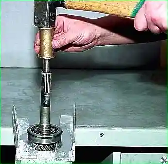 Оперев подшипник на жесткое основание, молотком через выколотку из мягкого металла выбиваем первичный вал