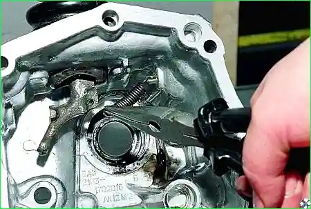 отсоединяем от рычага возвратную пружину