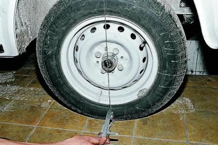 Штангенциркулем или линейкой измеряем расстояния от нити отвеса до верхней и нижней точек обода колеса