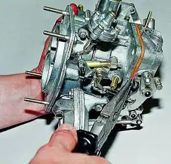 подгибая нижний выступ рычага оси дроссельной заслонки