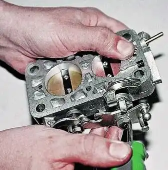 Разборка и ремонт корпуса дроссельных заслонок ДААЗ 2107 Отверткой отгибаем усик стопорной шайбы гайки оси