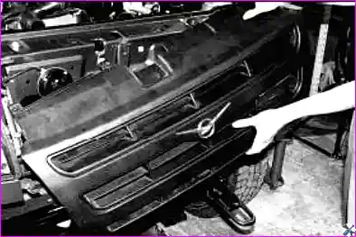 Откручивание двух нижних винтов крепления облицовки радиатора