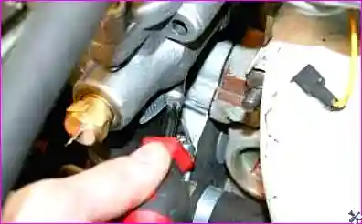 Ослабление верхнего хомута соединительного шланга между термостатом и водяным насосом