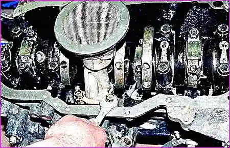 Отворачивание болта крепления кронштейна масляного насоса