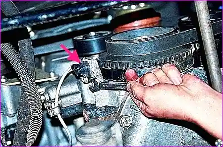 Датчик синхронизации (положения коленчатого вала), установленный на крышке цепи вблизи шкива