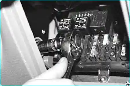 Процесс откручивания винтов боковых накладок панели приборов