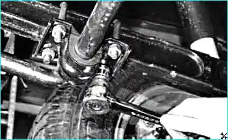 Отворачивание гайки болта нижнего крепления амортизатора