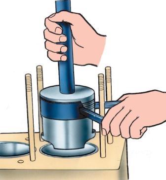 Tool for fitting a piston with rings into a cylinder