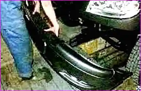 Процесс выворачивания болтов крепления бампера с левой стороны