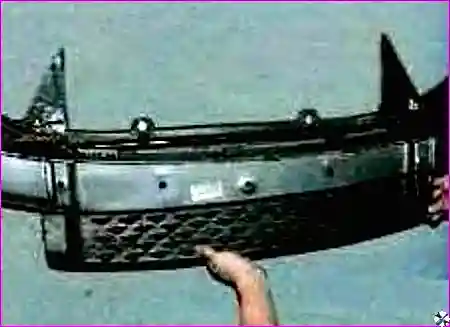 Процесс снятия переднего бампера после откручивания всех креплений