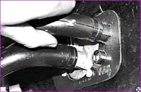 Ослабление хомутов и отсоединение шлангов от крана отопителя в подкапотном пространстве