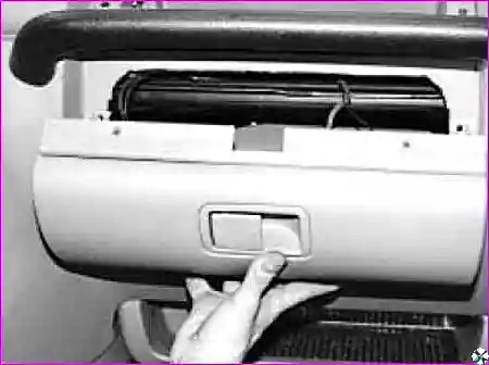 Извлечение нижнего вещевого ящика и отсоединение клеммы освещения